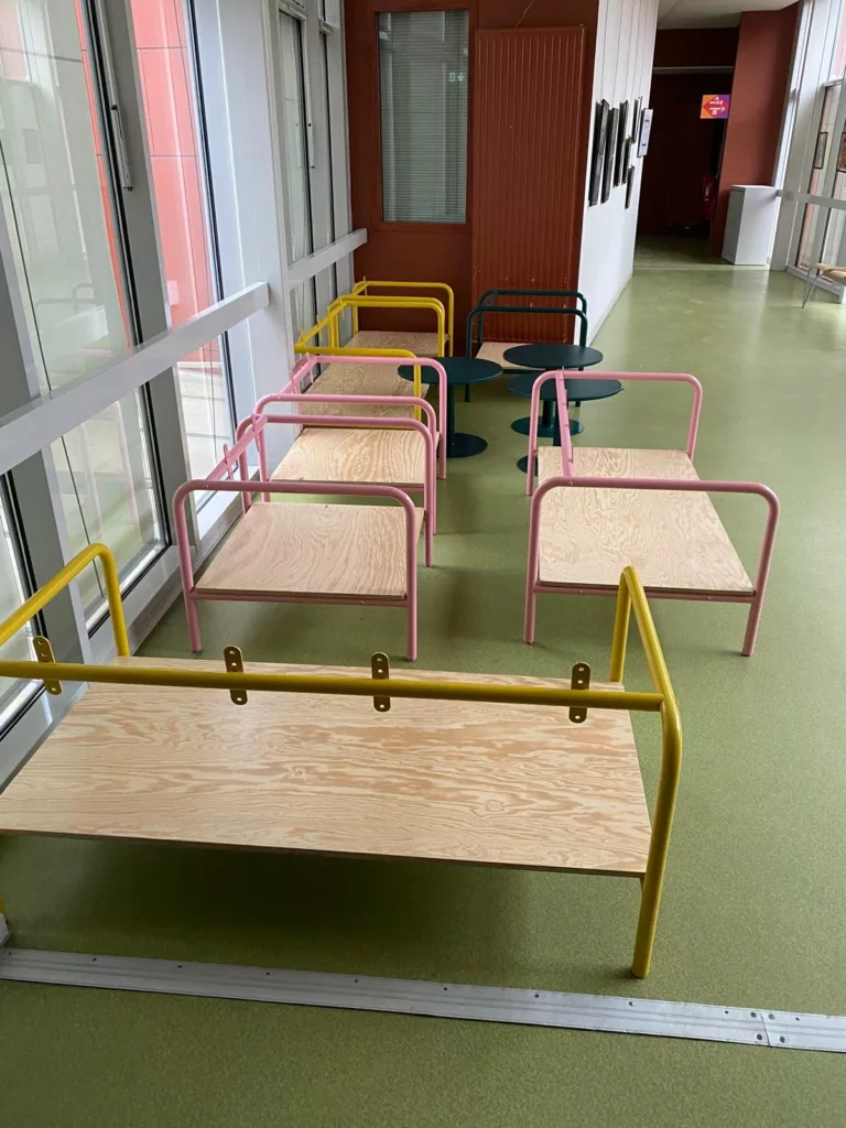Banquettes en tube acier jaune et rose avec assise en bois, fabrication BE PROCESS