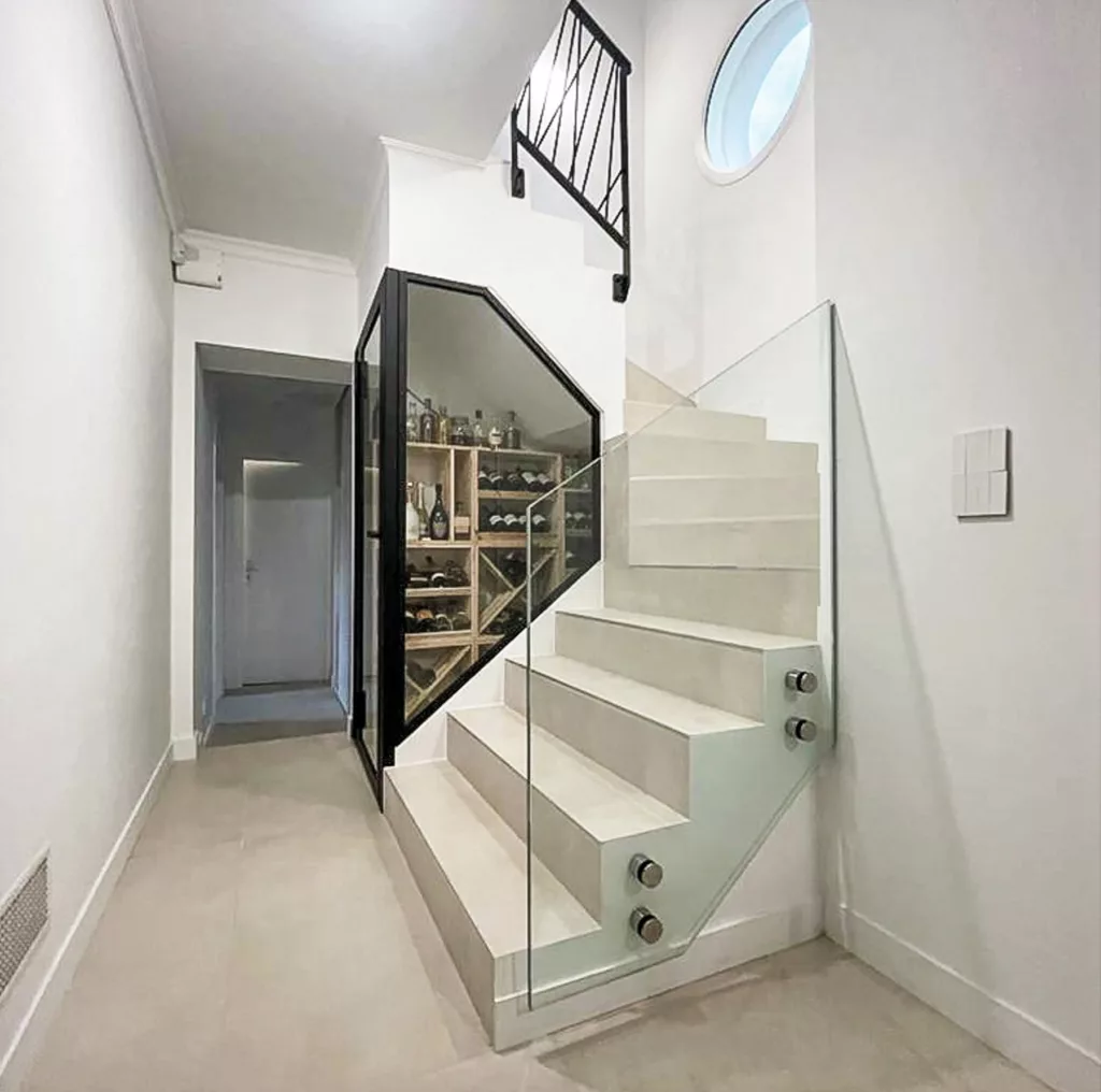Garde-corps vitré et structure acier de l'escalier au-dessus de la cave à vin