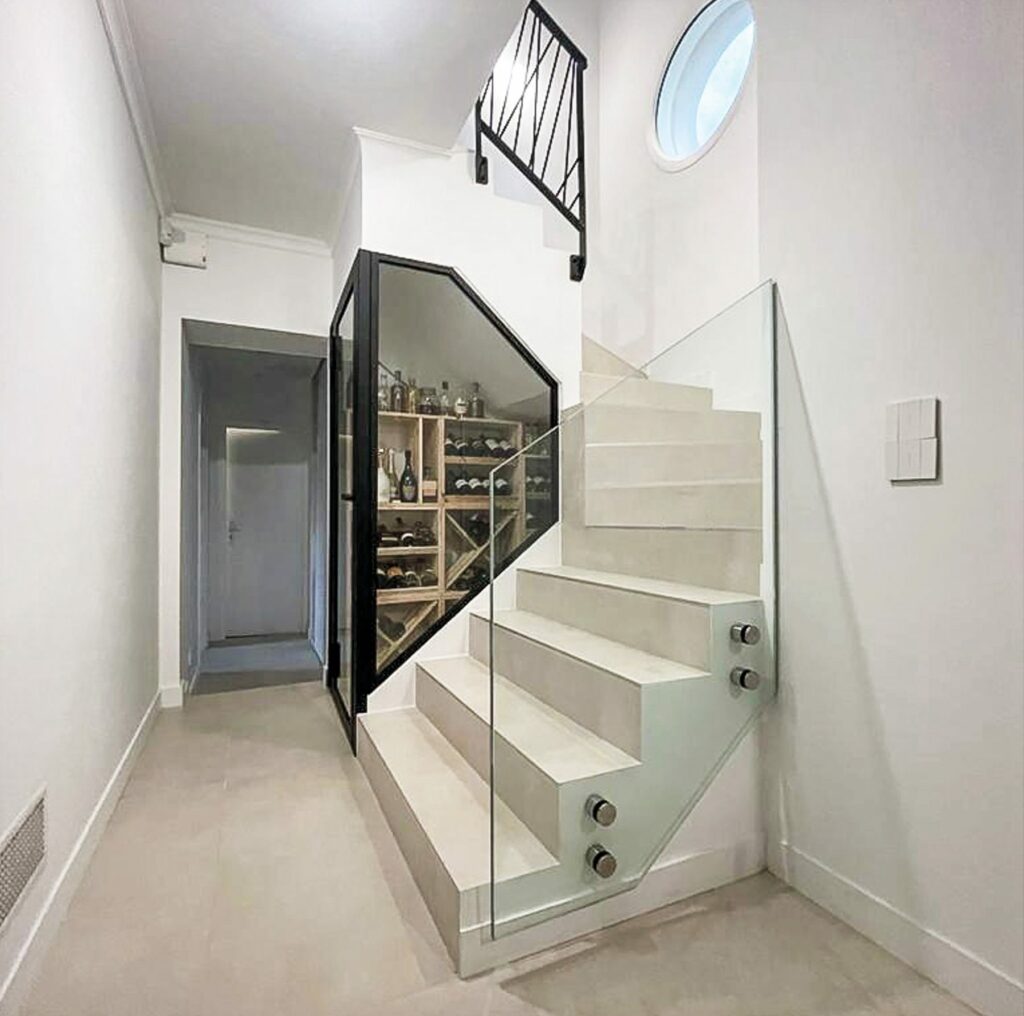 Garde-corps vitré et structure acier de l'escalier au-dessus de la cave à vin