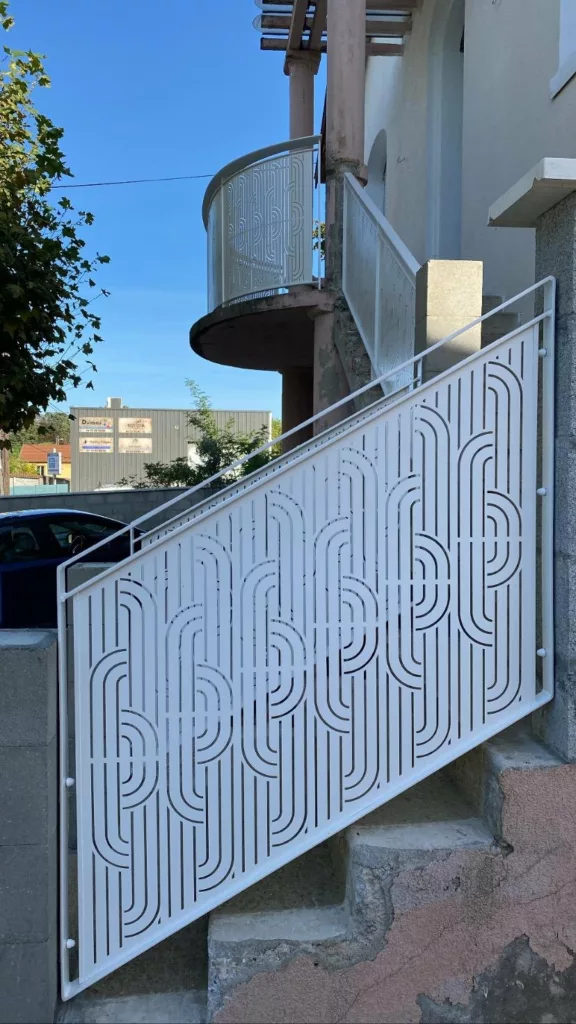 Rampe d'escalier extérieur en tôle découpée assortie au garde-corps du balcon cintré