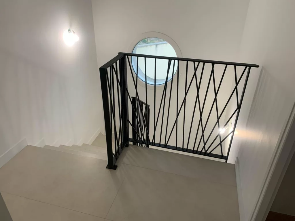 Garde-corps en acier noir à barreaux obliques sur la mezzanine d'une villa contemporaine