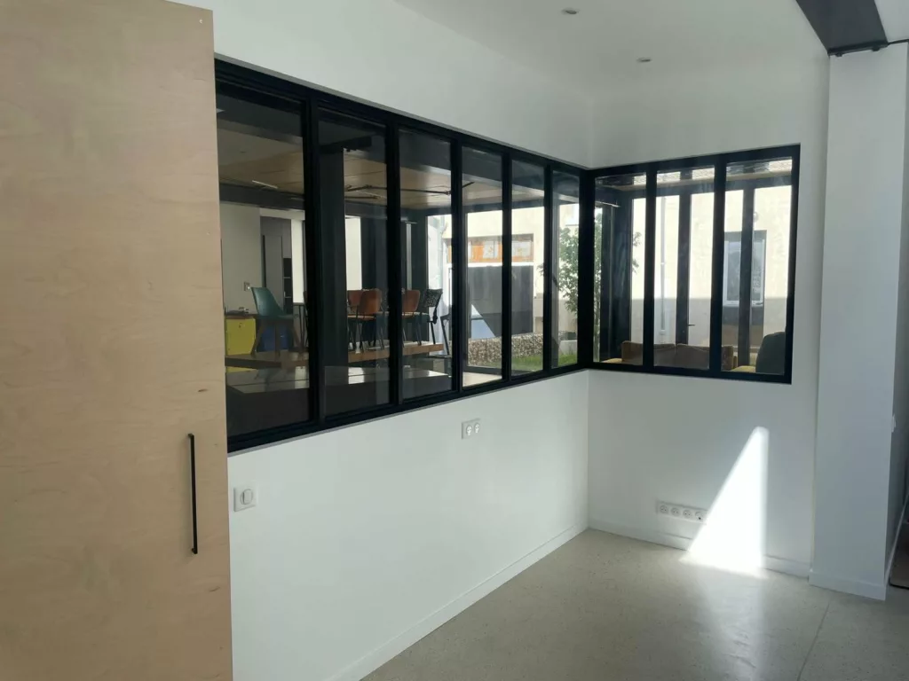 Vue intérieure du bureau fermé par la verrière acier, loft Villeurbanne