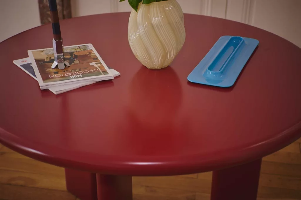 Détail du plateau de la table ronde en acier rouge
